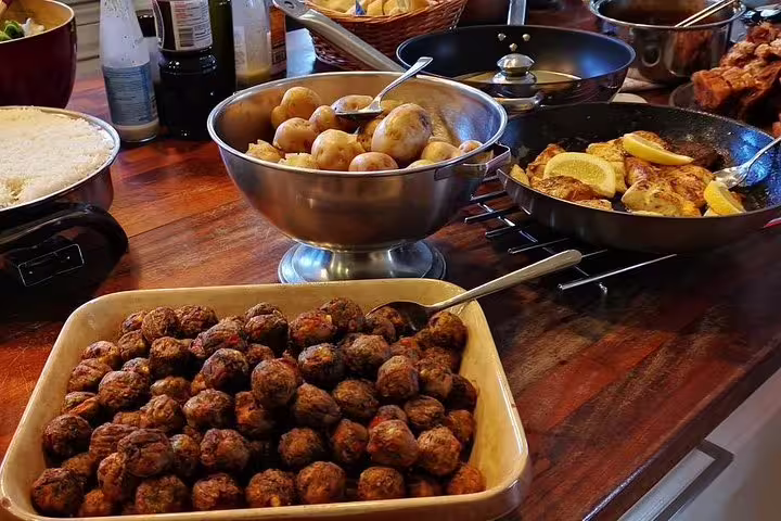 Buffet spread with meatballs, baby potatoes, lemon chicken, and rice for a home-cooked Icelandic meal