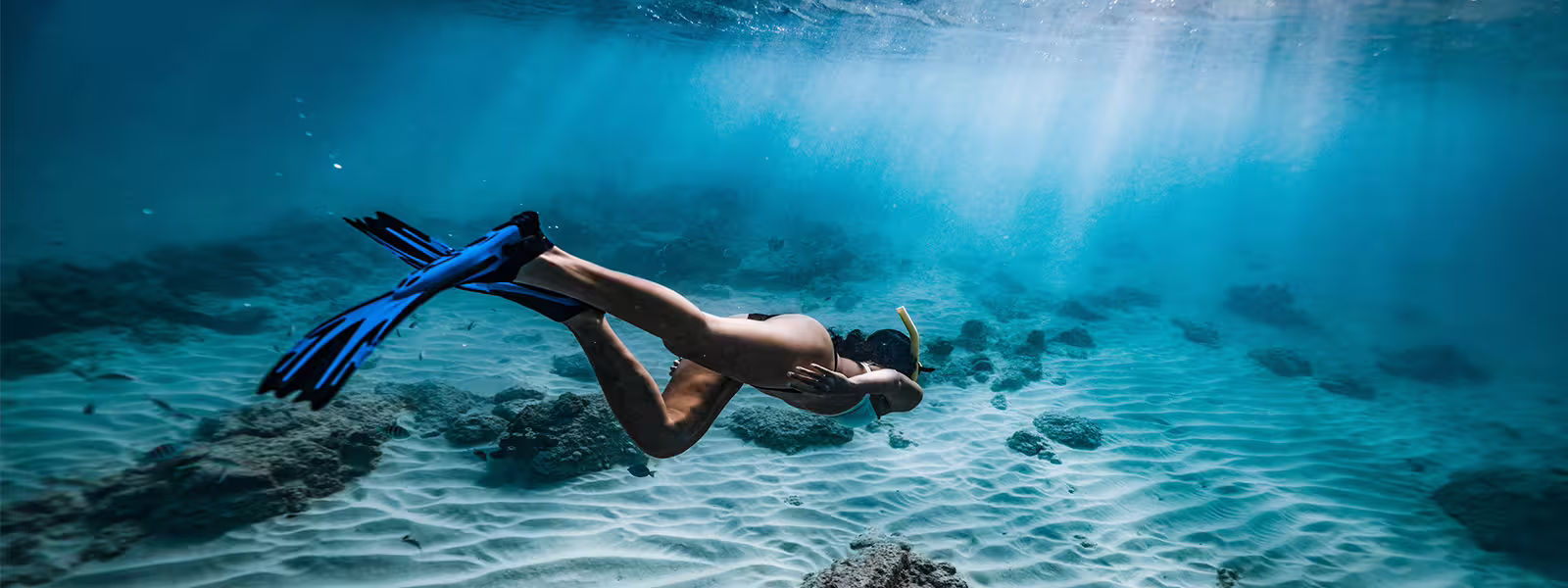 A snorkeler diving gracefully underwater, exploring Costa Brava's marine life and clear waters.