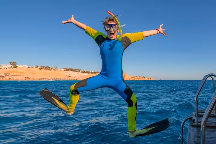 Snorkeler in wetsuit jumping off boat in Red Sea on White Island and Ras Mohamed snorkeling trip from Sharm