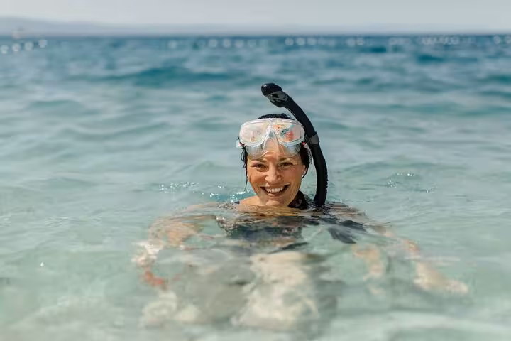 Snorkeler in clear Red Sea water on Dolphin House National Park full-day snorkeling trip, Hurghada Egypt