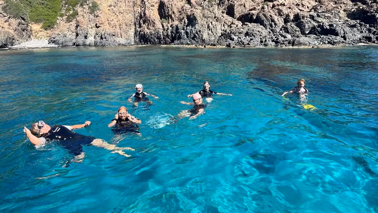 Snorkelers exploring the vibrant waters near the rocky cliffs of Capo Marrargiu, Bosa, perfect for marine adventures.