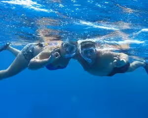 Two snorkelers swimming underwater in clear blue sea at Giftun Island