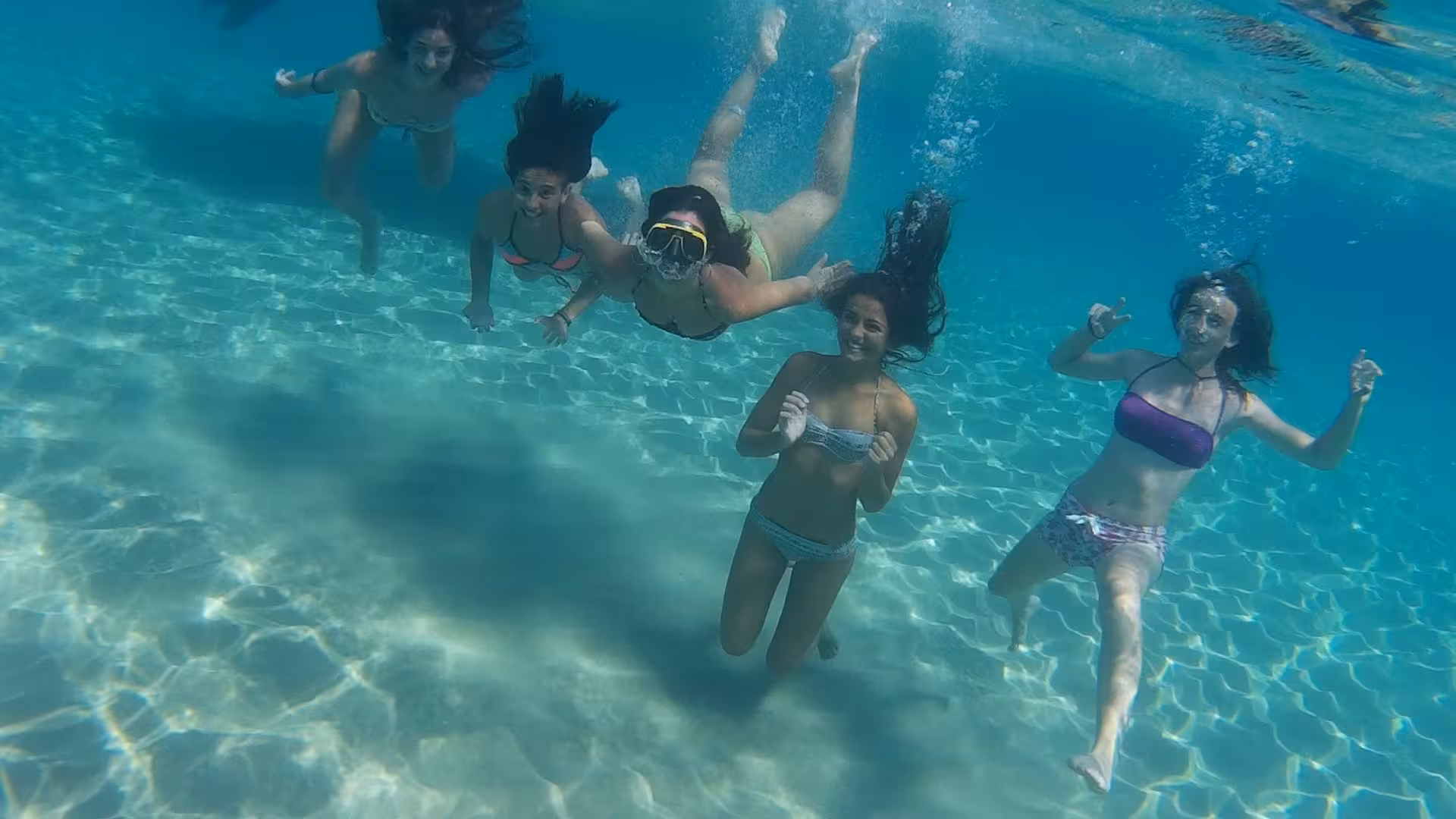 Group of friends snorkeling in the crystal-clear waters of Orosei Gulf, showcasing the vibrant marine life from Cala Gonone.