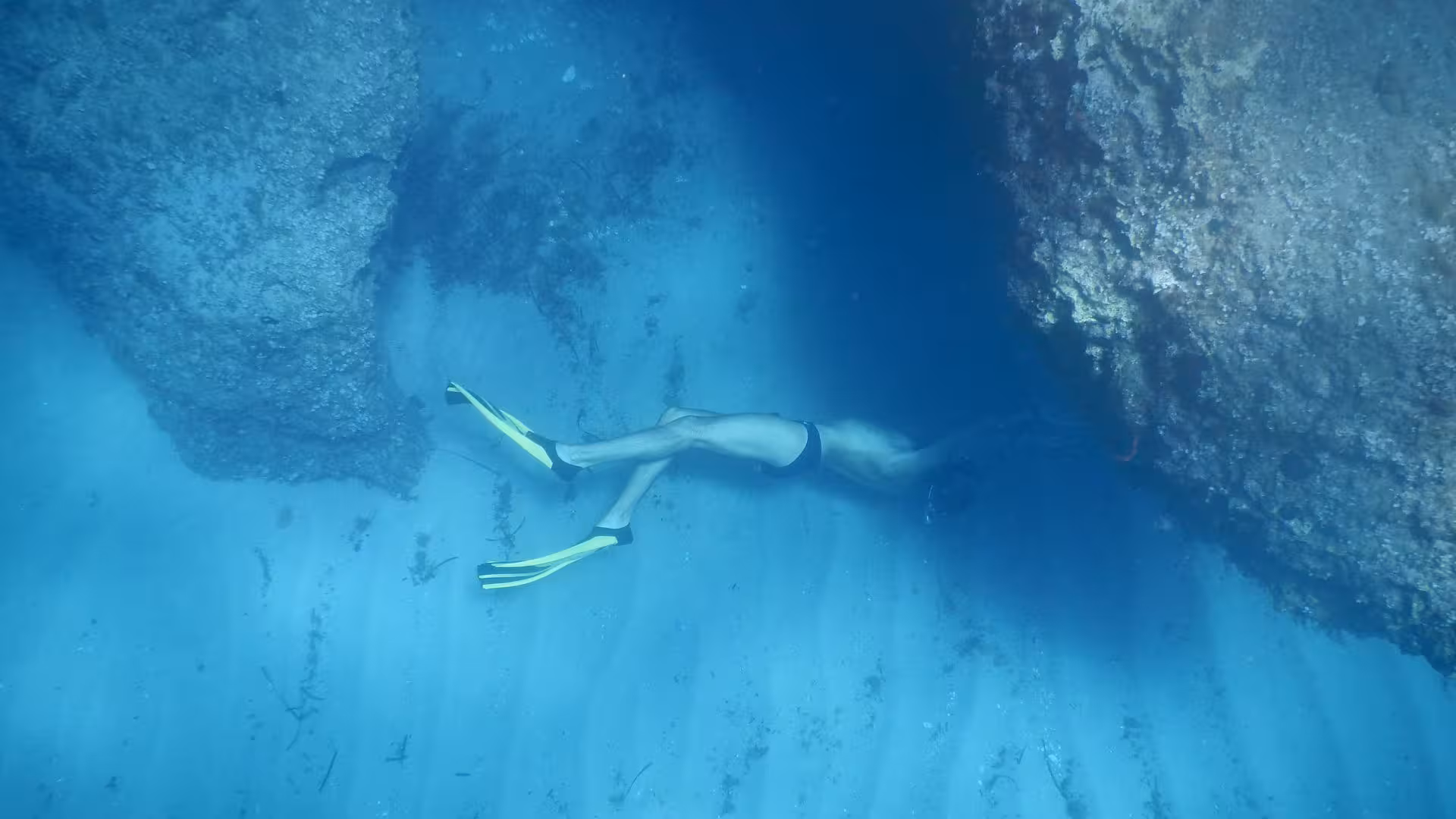 Snorkeler investigates a rocky underwater cave in the Orosei Gulf, highlighting adventure and exploration.