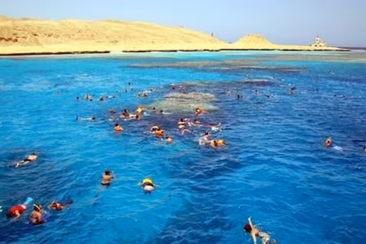 Snorkelers exploring Red Sea coral reef in Hurghada, a top snorkeling day trip from Luxor with clear water