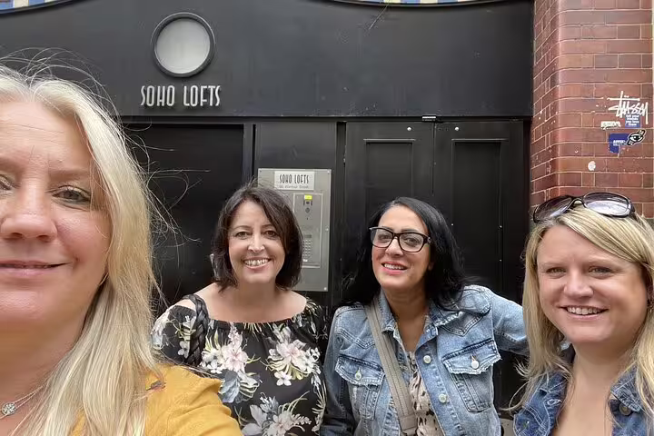 Four women smiling outside Soho Lofts building on a Soho walking tour