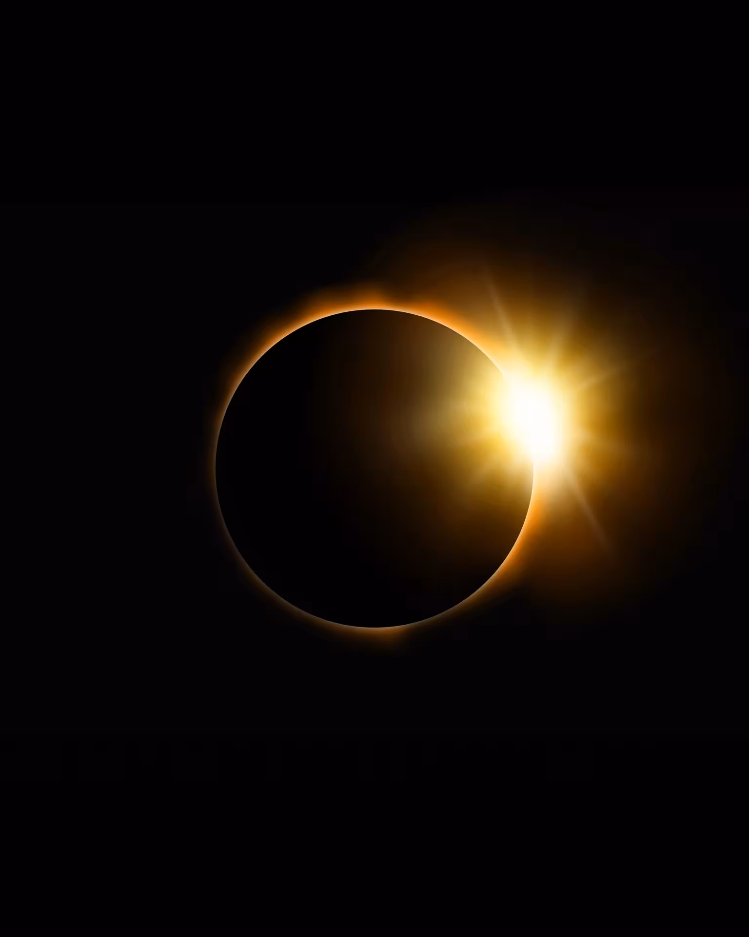 Diamond ring effect during total solar eclipse with golden corona glow against black sky
