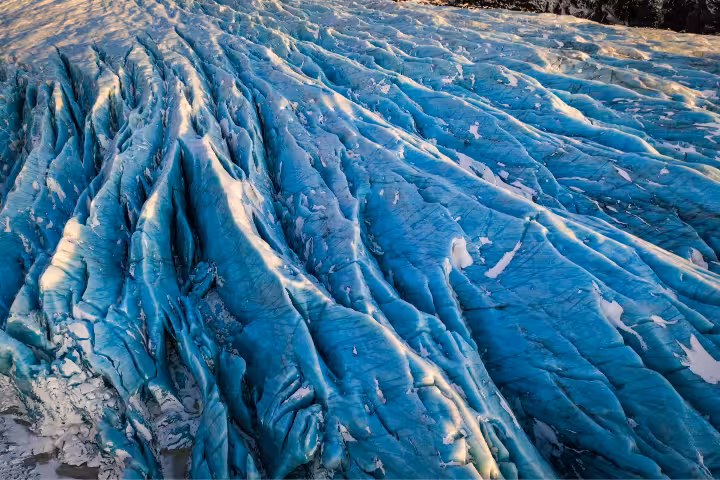 Blue glacial ice formations with deep crevasses on Solheimajokull glacier in Iceland