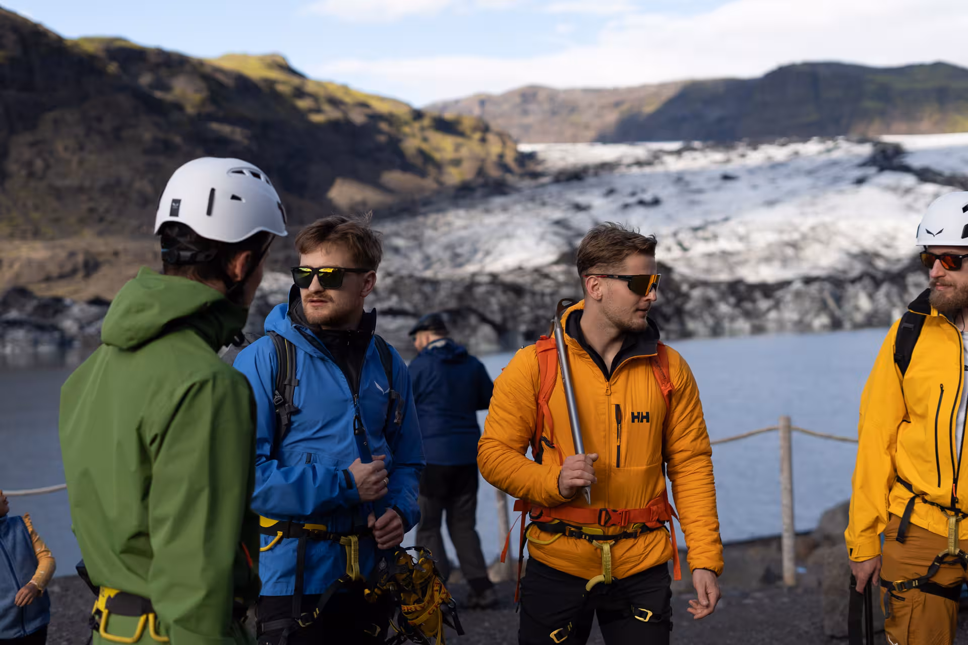 Guided Sólheimajökull glacier hike group gearing up by the lagoon on Iceland South Coast tour