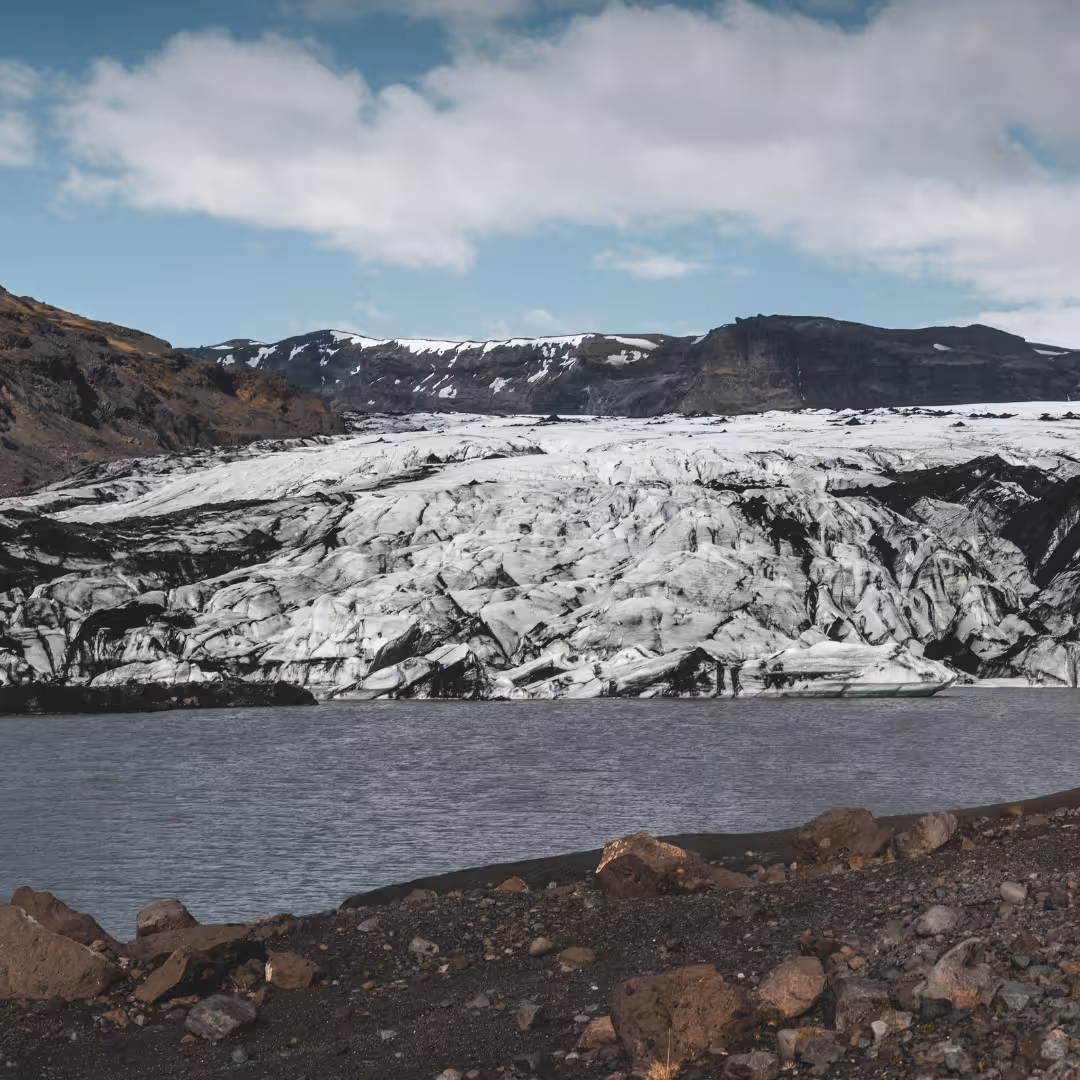Stunning view of Solheimajokull Glacier with glacial lagoon and volcanic black sand on Iceland South Coast day trip