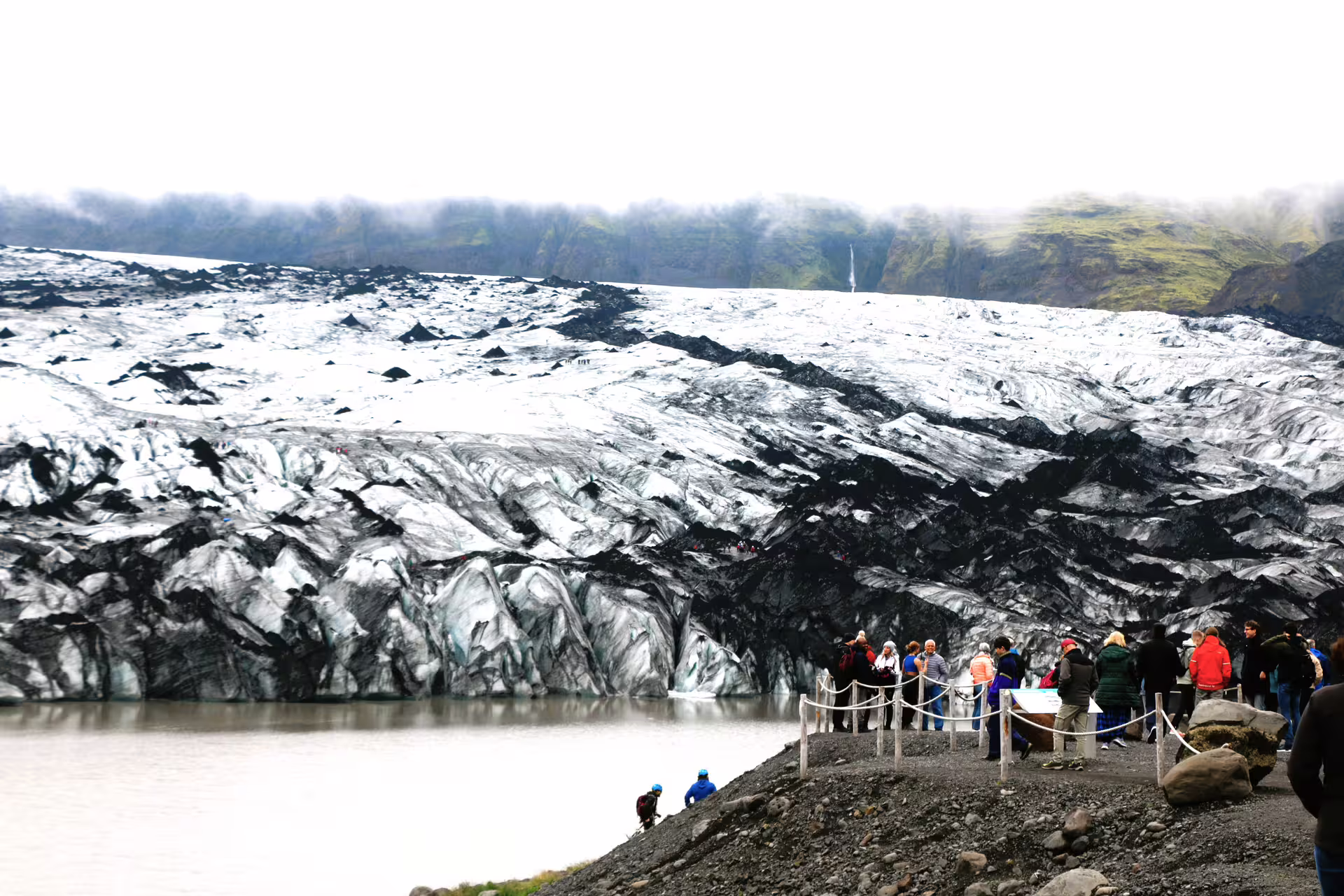 Tourists viewing Sólheimajökull glacier and glacial lagoon on Iceland's South Coast tour