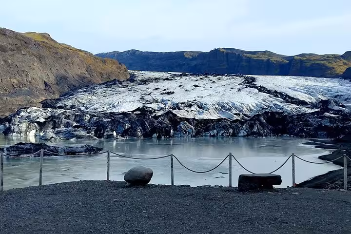 Sólheimajökull glacier and glacial lagoon viewed from a fenced viewing platform near Vik, Iceland