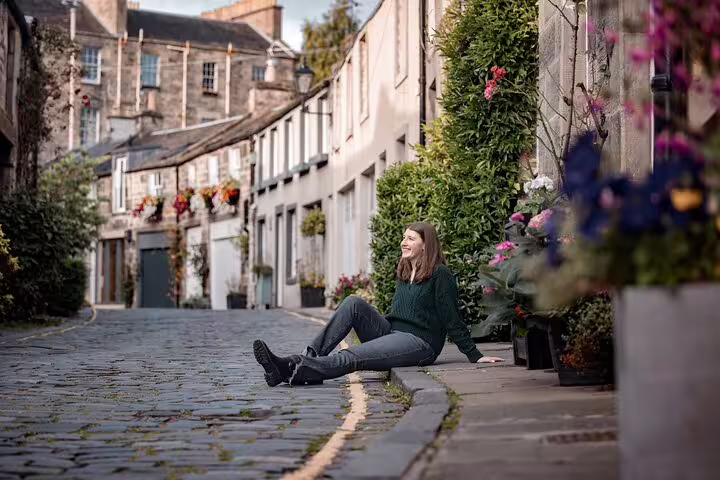 Solo traveler posed on cobbled Dean Village street during private Edinburgh photoshoot with pro photographer