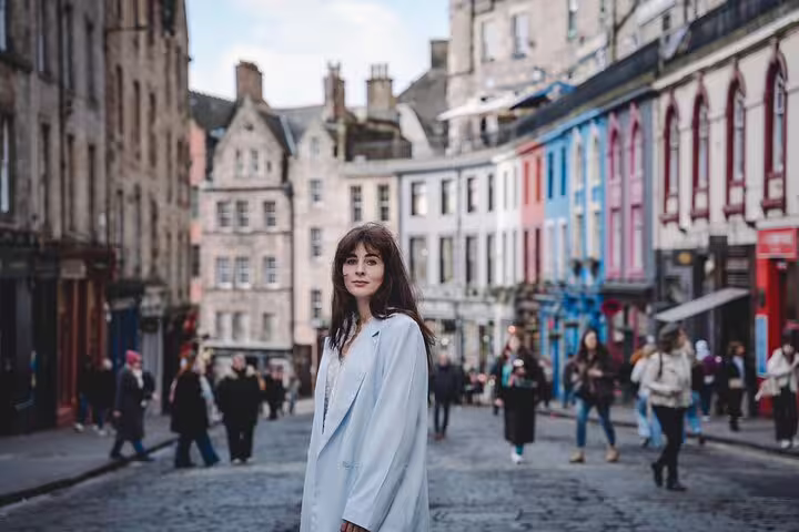 Solo traveler posing on Victoria Street for a private Edinburgh photoshoot with a professional photographer