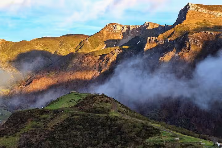Scenic view of Somiedo Natural Park's majestic mountains and rolling hills, highlighted in Oviedo village tours.