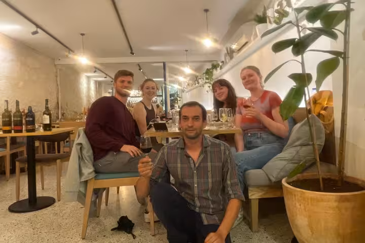 Sommelier-led small-group tasting in Porto, guests toasting five Port wines in a cozy wine bar with modern decor