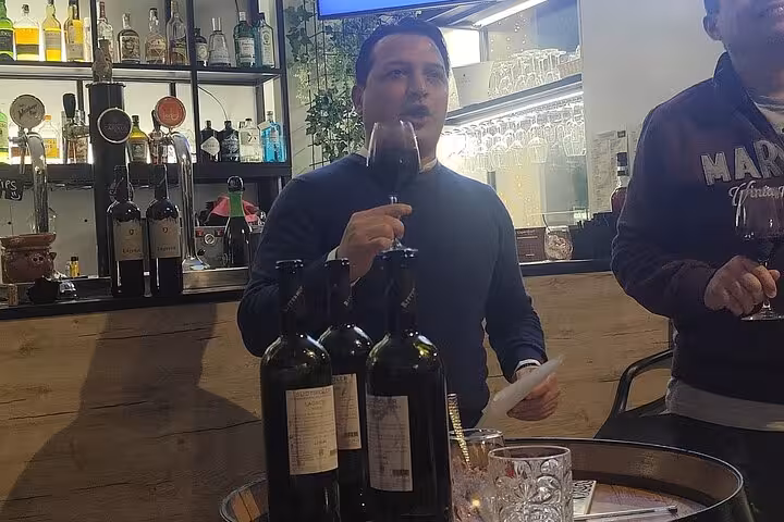 Sommelier in Rome leading a wine tasting session, highlighting premium bottles in a cozy wine bar setting.