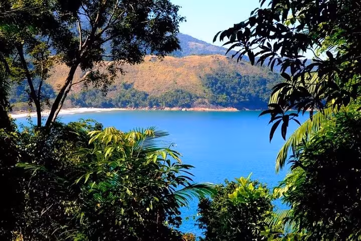 Scenic view of lush greenery and blue waters at Sono Beach on Paraty adventure experience.