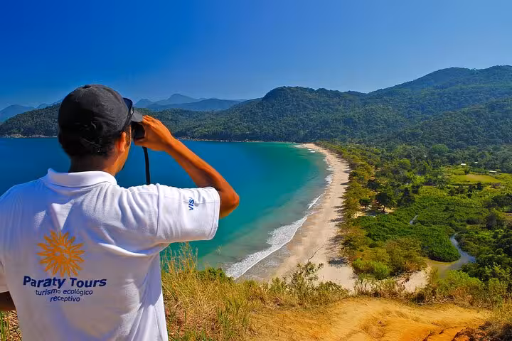 Tour guide overlooking the stunning coastline of Sono Beach from a scenic viewpoint with Paraty Tours.