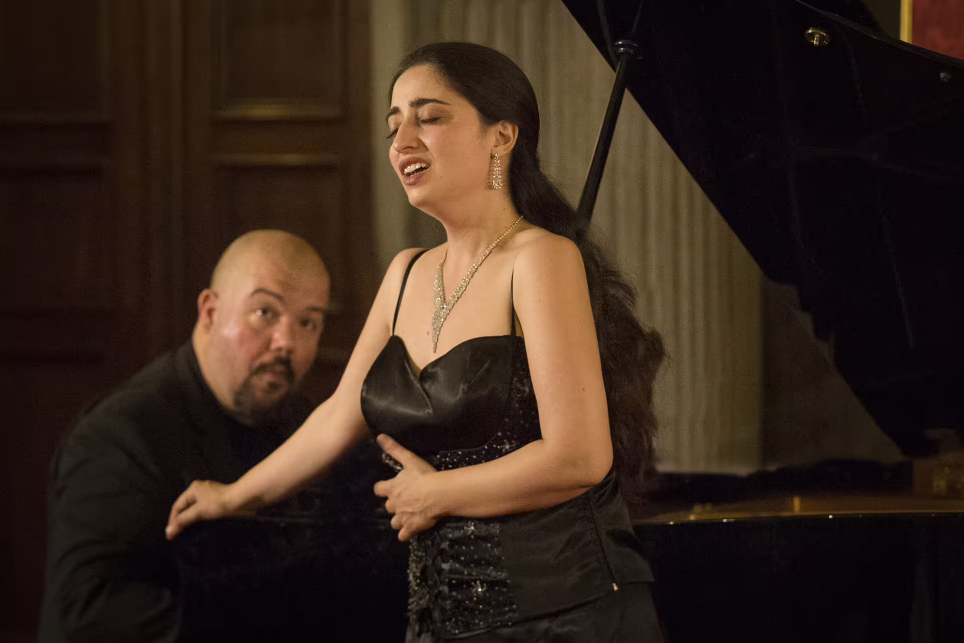 Soprano singing with pianist during Italian opera concert in Santa Monaca Church, Florence