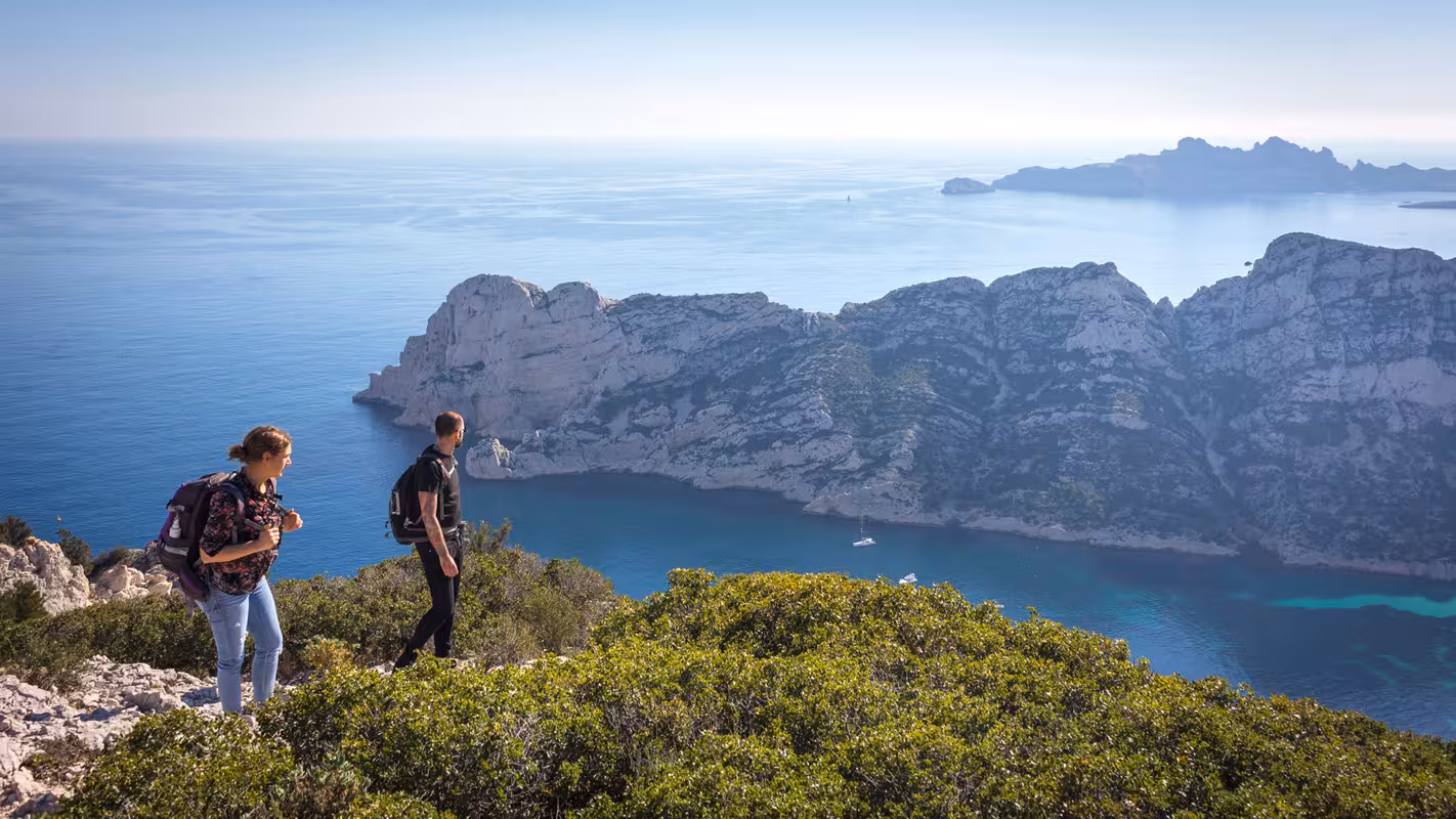 Hikers overlooking Sormiou and the Calanques National Park cliffs near Marseille on a scenic coastal trekking tour