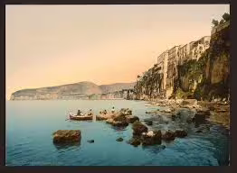 Traditional fishing boat gliding along Sorrento’s dramatic cliffs at sunset on a scenic Amalfi Coast small-group day tour