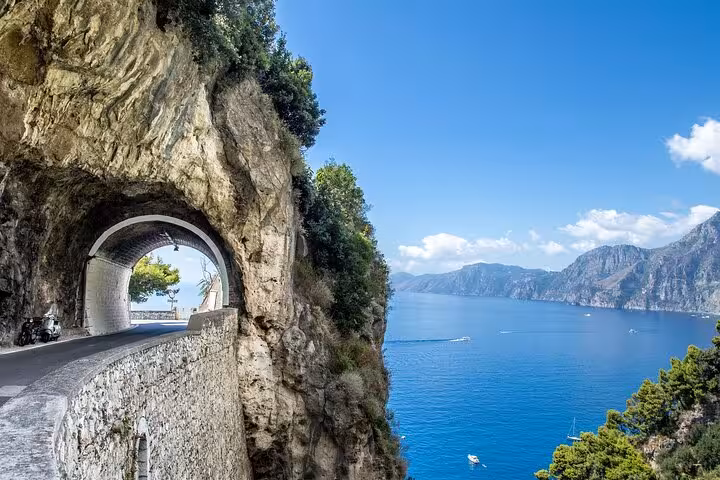 Picturesque coastal road and tunnel along the Amalfi Coast with breathtaking sea views from Sorrento tour.
