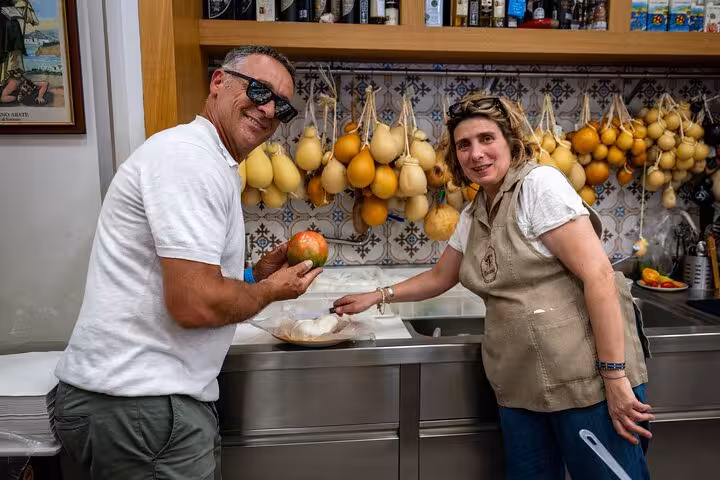 Tour participants sampling fresh produce and cheeses in a local Sorrento shop during the Bites & Sips Tour.