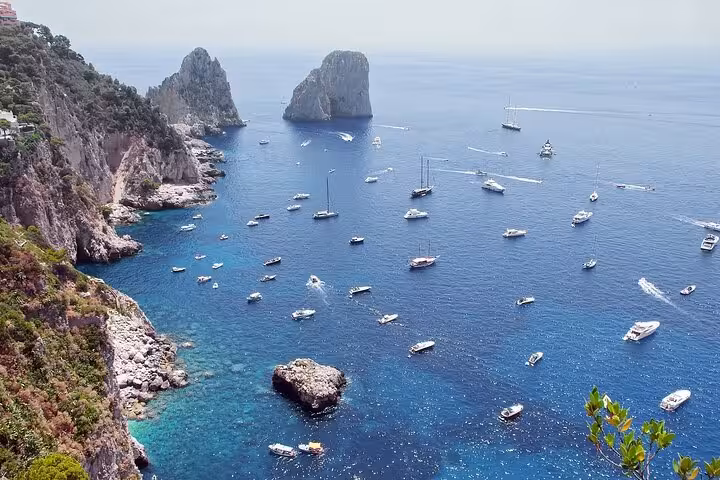 Stunning aerial view of boats in the crystal-clear waters near Sorrento Coast and Capri's iconic rock formations.