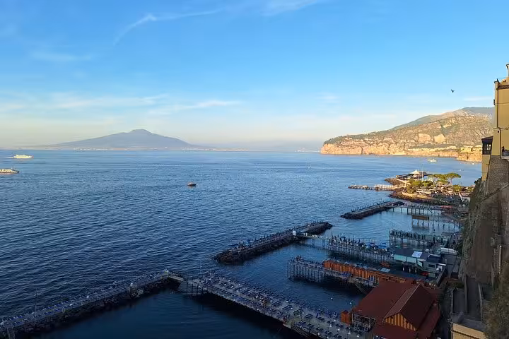 Stunning view of Sorrento coastline with clear blue sea and Mount Vesuvius in the background.
