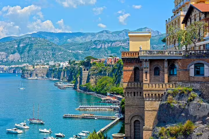 Sorrento coastline with marina and cliffside buildings, highlight of customizable Pompeii and Amalfi Coast tour