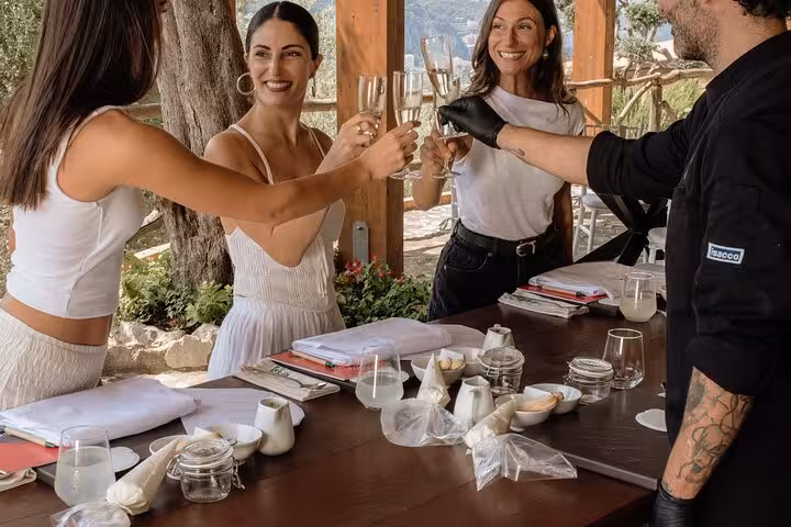 Guests enjoying a toast during the Sorrento Cooking Class with a local chef under a rustic pergola.