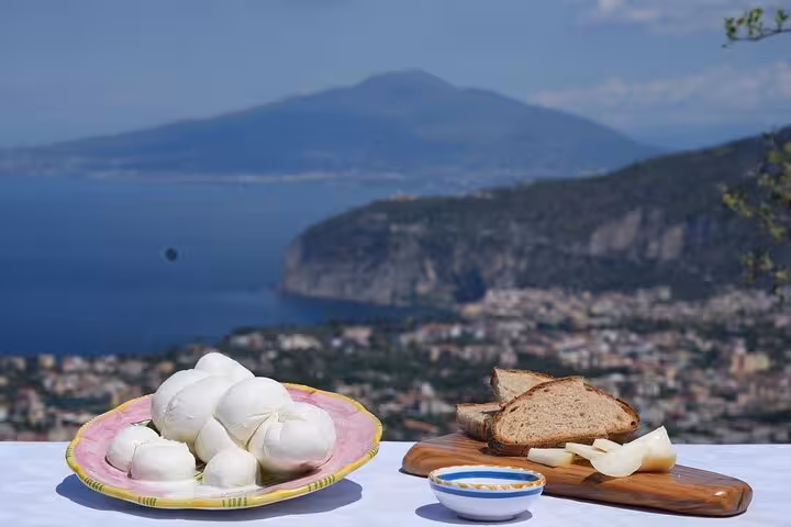 Scenic view of fresh mozzarella and bread with a coastal backdrop, perfect for an authentic farm-to-table pizza experience.