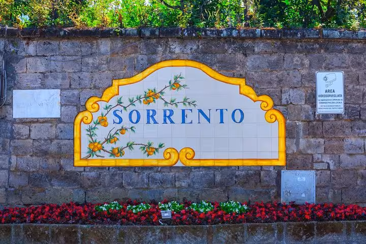 Vibrant Sorrento sign adorned with floral tiles, highlighting the charm of Sorrento on the Naples to Pompeii tour.