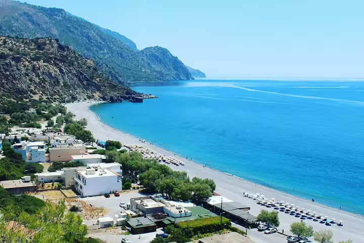 Aerial view of Sougia Beach, showcasing azure waters, sandy shores, and nearby village accommodations.