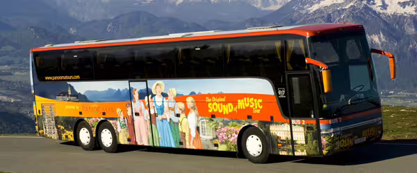 Tour bus for The Original Sound of Music Tour with scenic Alpine backdrop, promoting Edelweiss Cooking Class experience.
