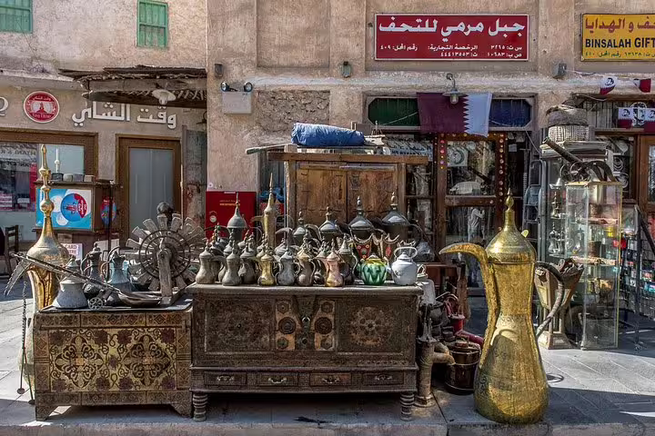 Antique coffee pots and traditional decor at a Souq Waqif market stall in Doha, showcasing local craft heritage.