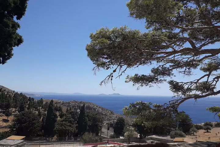 Breathtaking view of the Aegean Sea and lush greenery from the South Coast of Crete under a sunny sky.