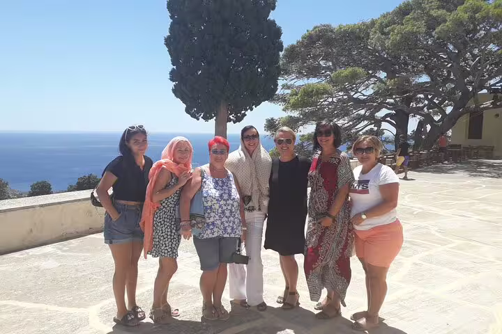 Group of tourists enjoying a scenic view of the sea on the South Coast of Crete during a sunny day.