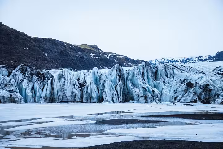 Massive glacier face with blue ice formations and frozen lagoon on Iceland's south coast