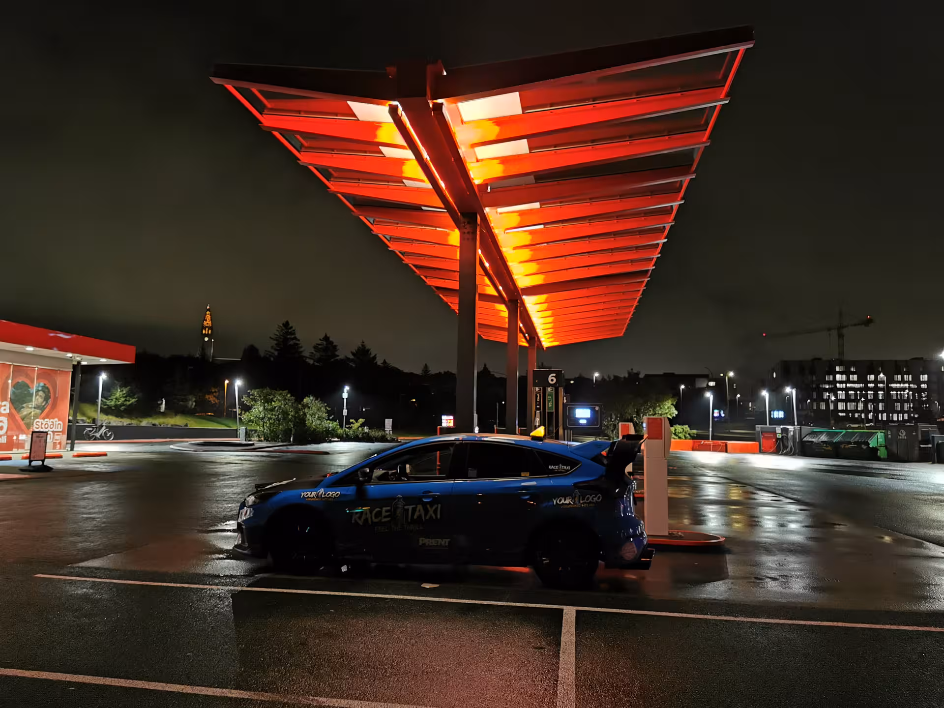 Rally car parked under glowing canopy at night, South Coast Adventure Rally Car Edition urban pit stop