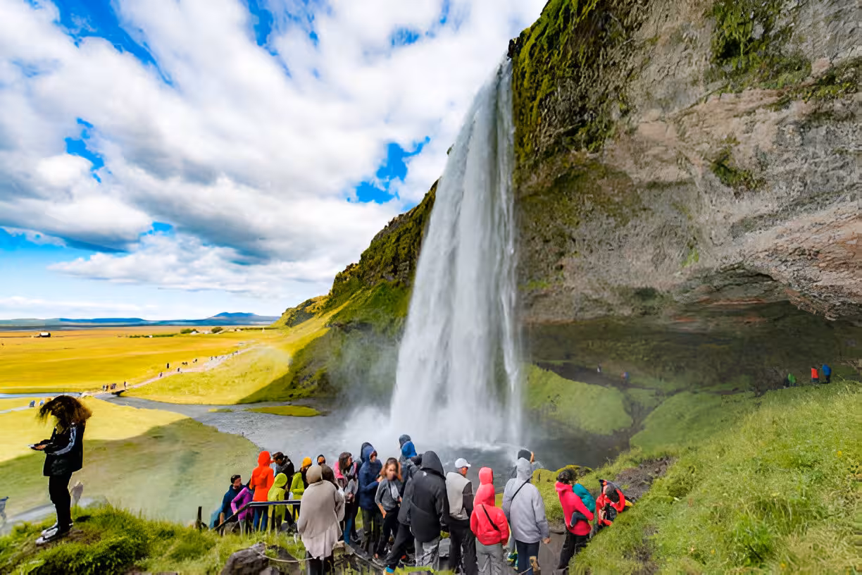 Tourists gathered at the base of Seljalandsfoss waterfall on Iceland's scenic south coast