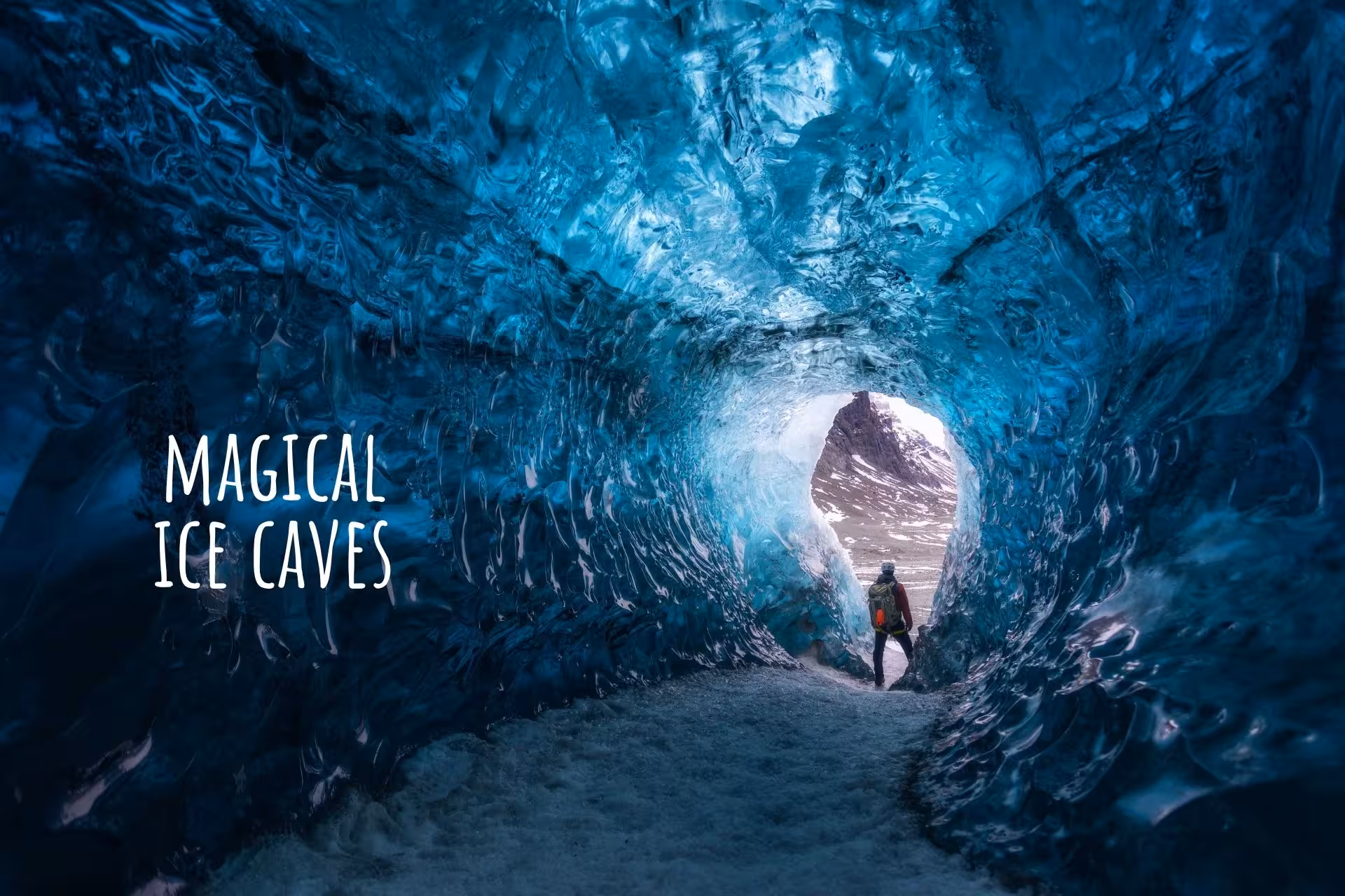 Explorer standing inside a glowing blue glacial ice cave tunnel in South Iceland