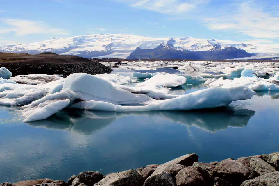 Floating icebergs on Jökulsárlón Glacier Lagoon with snow-capped mountains in South Iceland