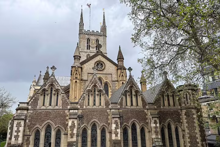 Gothic facade of Southwark Cathedral with pointed arches and stone tower under cloudy London sky