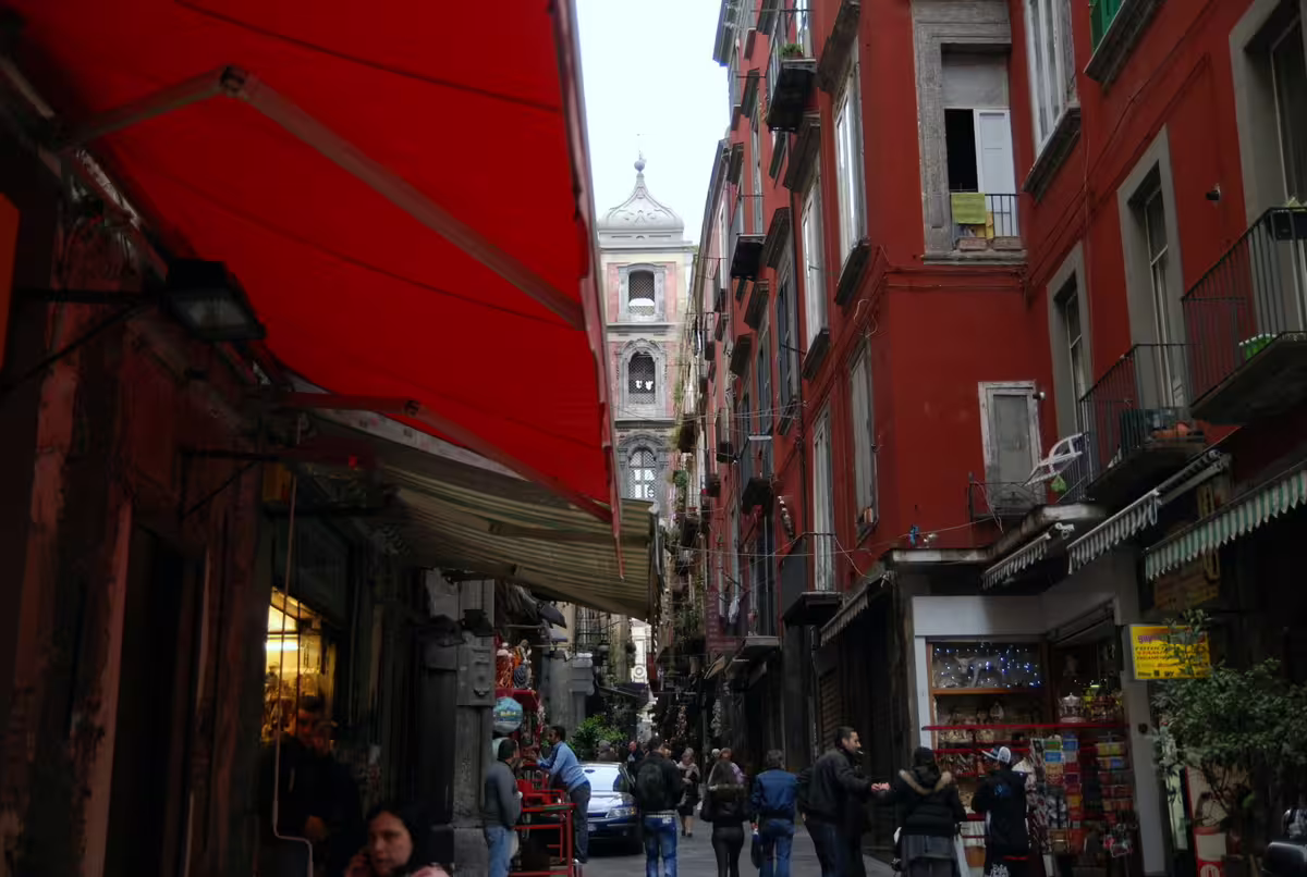 Lively Spaccanapoli alley in Naples historic center, explored on daylight city walking tour with scenic bus views