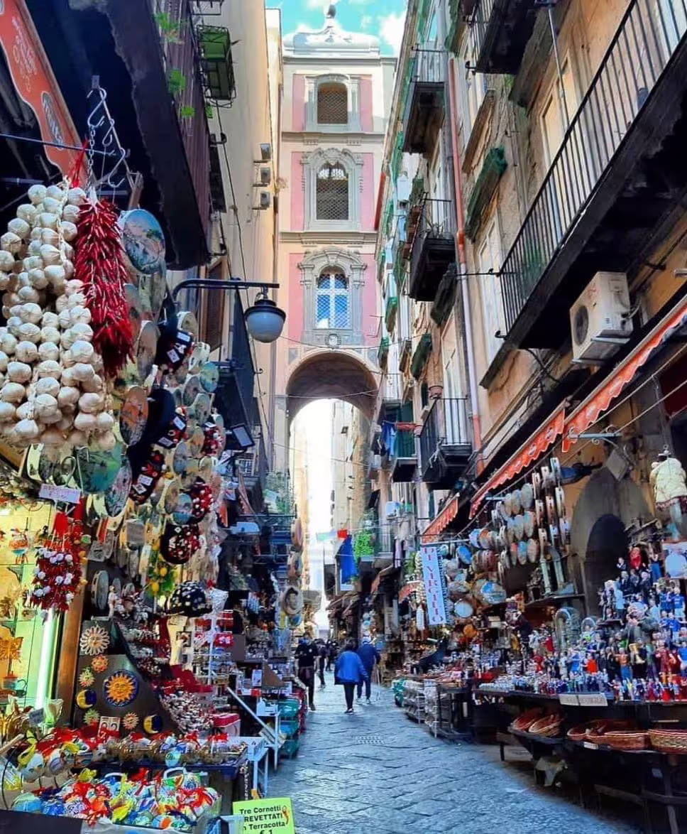 Spaccanapoli market alley with souvenir stalls and archway, on Naples Daylight guided walking tour downtown