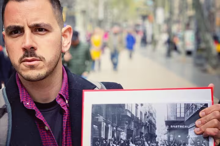 Tour guide holding historical photo on Barcelona street, illustrating Spanish Civil War insights on Franco walking tour.