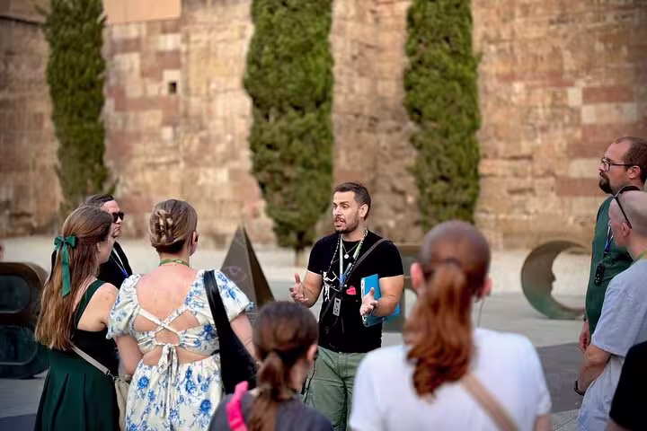 A tour guide leads a group through historic Barcelona, discussing the Spanish Civil War and Franco's impact.