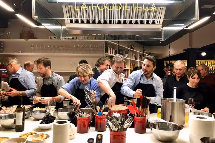 Participants engaged in a hands-on Spanish cooking class in a stylish loft, preparing authentic paella and tapas dishes.